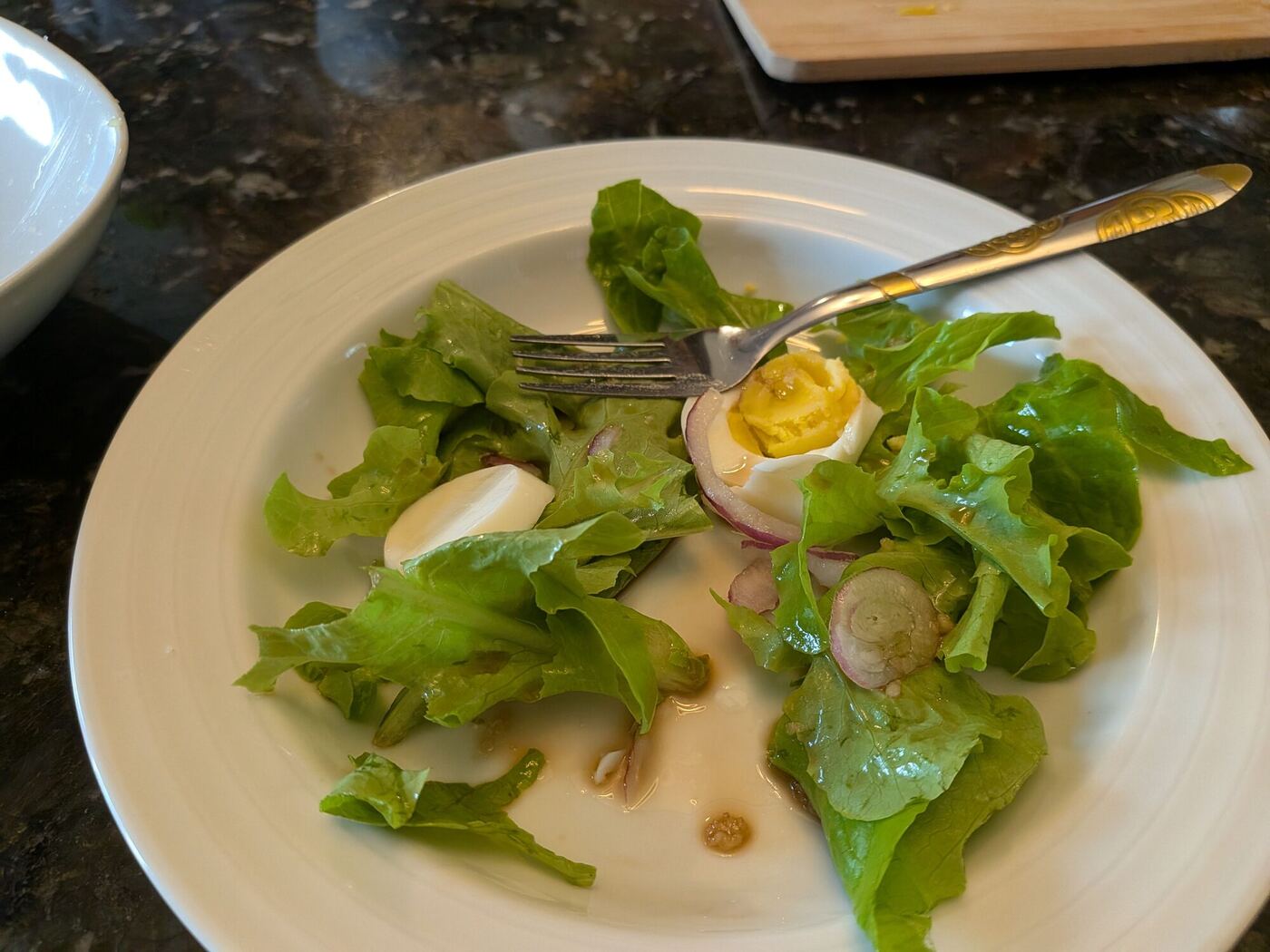 A plate of garden lettuce with sliced egg and onion