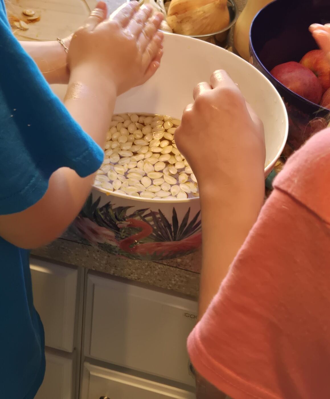 Hands rinsing pumpkin seeds in a bowl