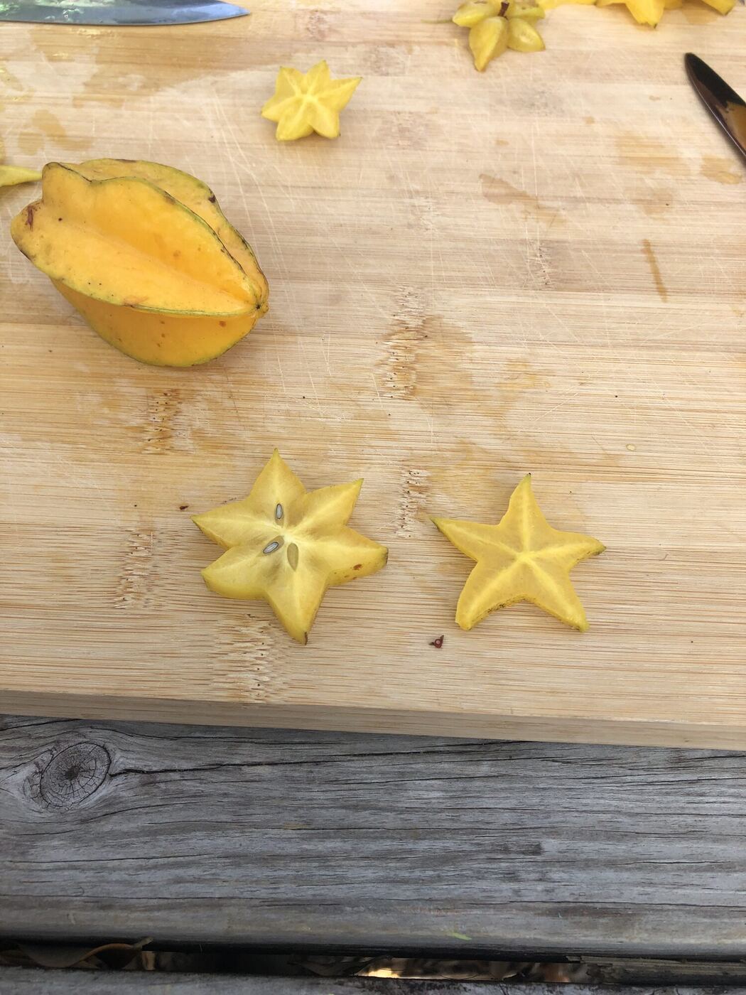 Slices of starfruit, cut into stars, on a wooden board