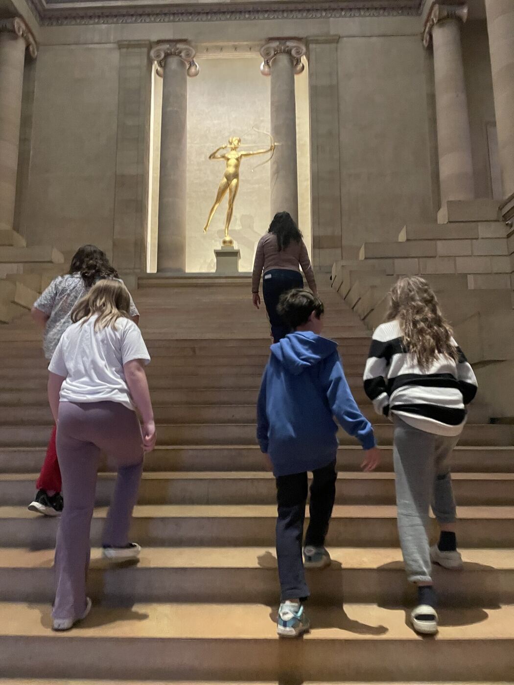 The group from behind, climbing the great stair of the art museum