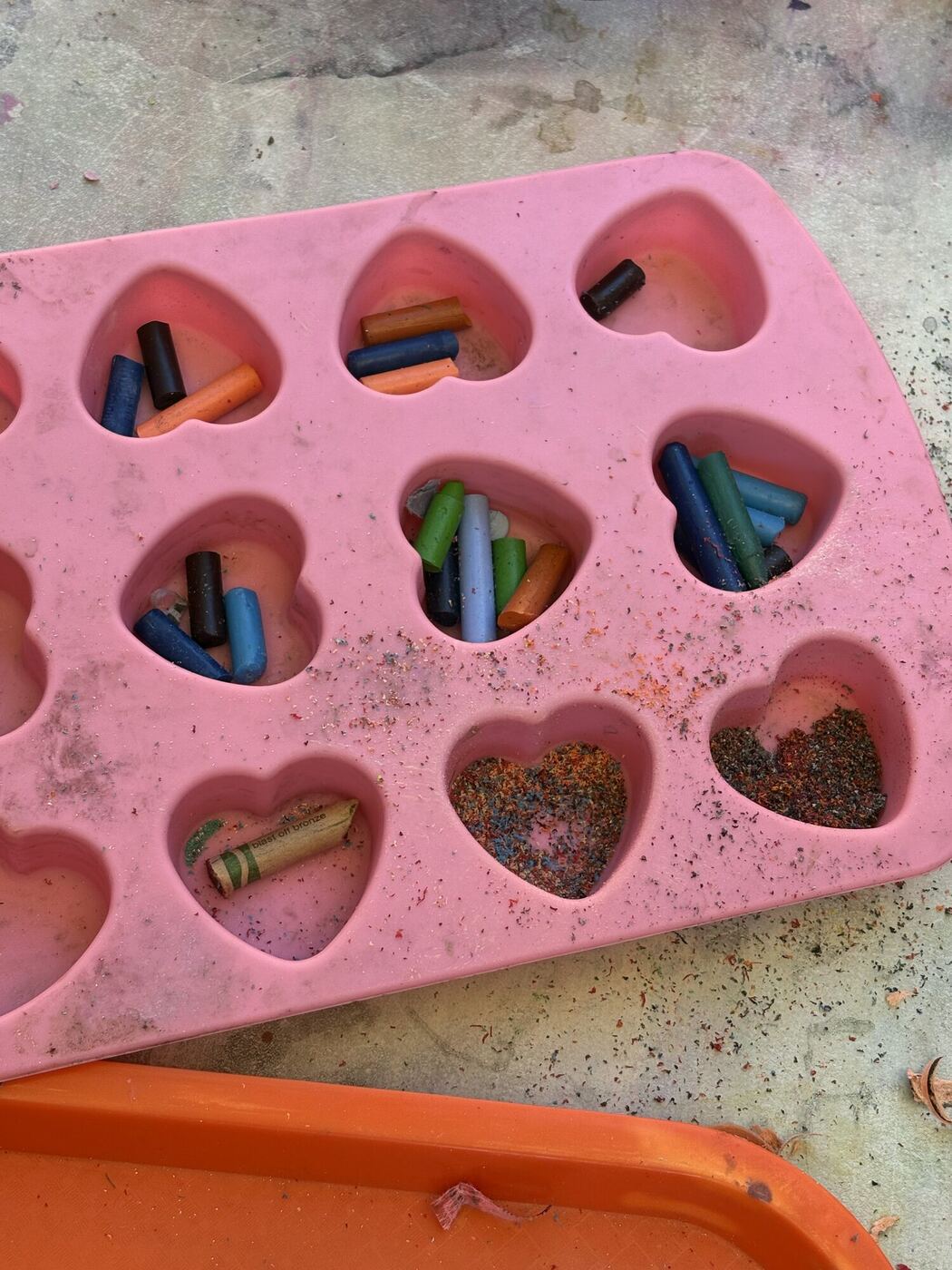 Crayon pieces sorted into a pink heart-shaped mold