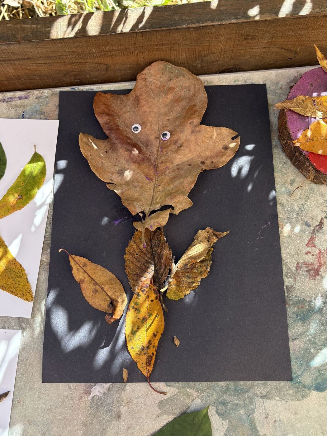 A leaf creature with an oak-leaf head on black paper
