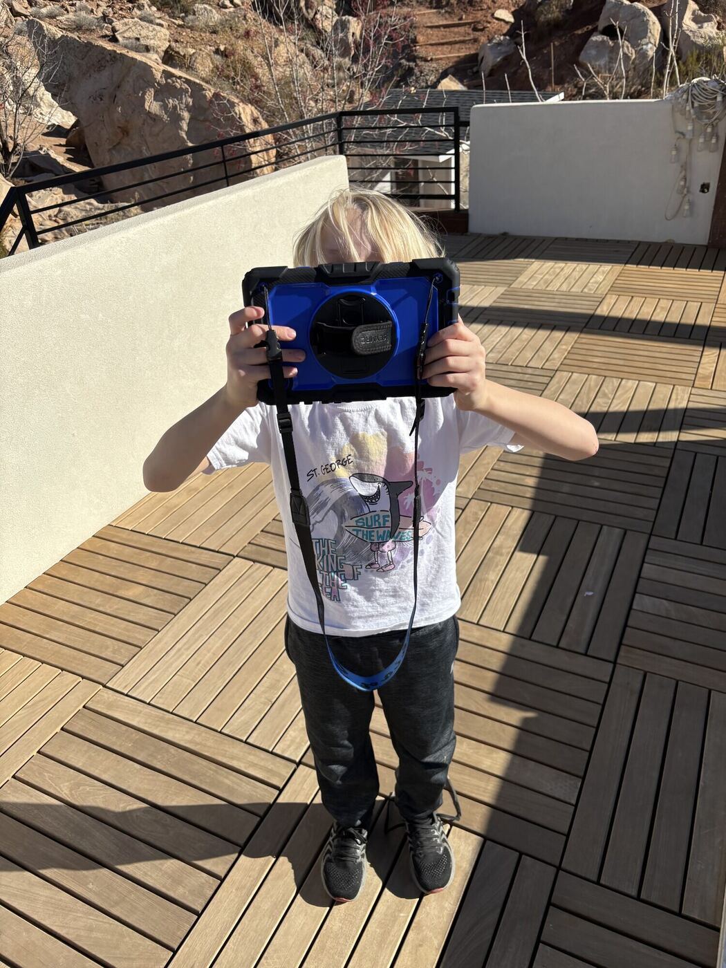 A tablet held up to frame a shot on the deck, the camera operator hidden behind it