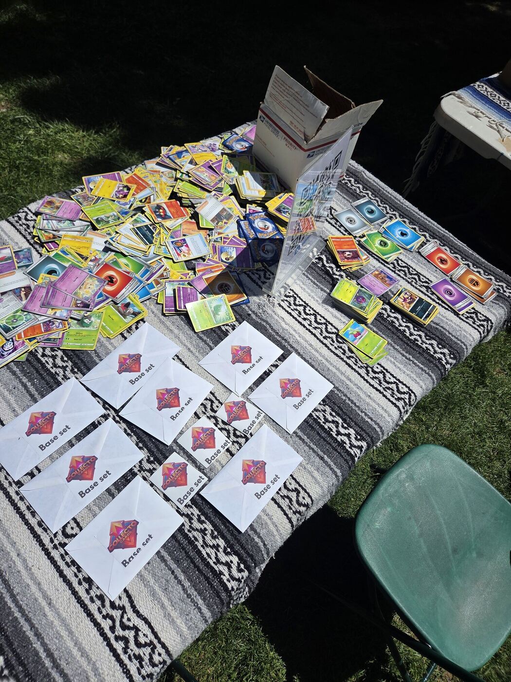 A market stall laid out on a blanket: trading cards and hand-made packs