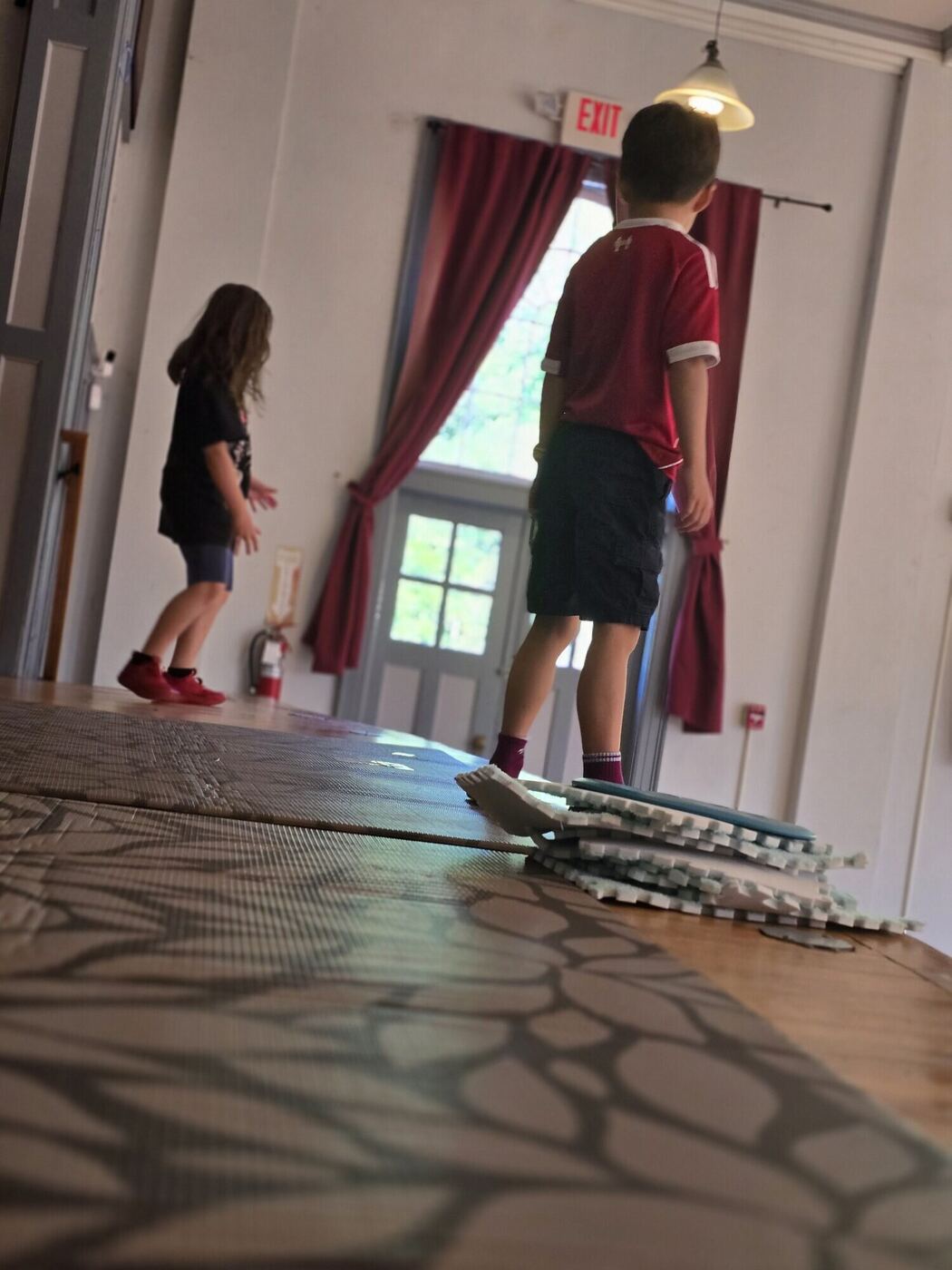 Two players mid-scene in the hall, seen from behind across the floor